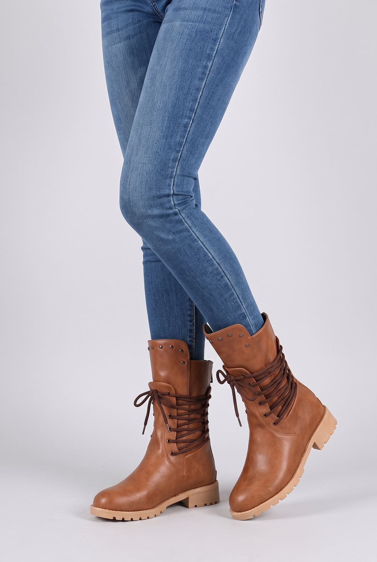 NOLA model wearing lace-up mid-calf boots lug sole studded